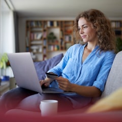 Smiling woman doing online shopping on laptop at home