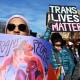 A protester holds a sign that reads, "Trans Lives Matter."