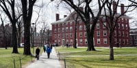 People walk through the campus of Harvard University in Cambridge, Mass., Tuesday, March 18, 2025.