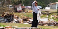 Stacy Thompson looks out over the wreckage of her mother Lola Weatherly’s trailer and those of her neighbors in Selmer, Tenn., after a suspected tornado tore through the town early Thursday morning on April 3, 2025. 