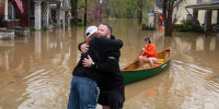 Thomas Fenwick, 42, and Jo Rodriguez, 33, embrace as their neighborhood floods on April 6, 2025 in Frankfort, Ky.
