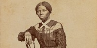Harriet Tubman sits in a chair, posing for a portrait