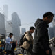 People cross a road on their way to work in Beijing's central business district on April 10, 2025. 