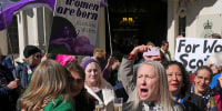 Members of "For Women Scotland" celebrate outside the U.K. Supreme Court in London after it ruled that a woman is someone born biologically female on April 16, 2025. 
