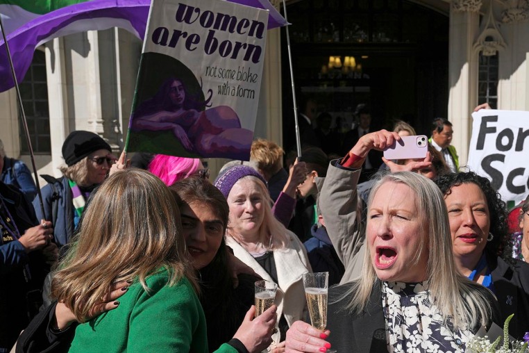 Members of "For Women Scotland" celebrate outside the U.K. Supreme Court in London after it ruled that a woman is someone born biologically female on April 16, 2025. 